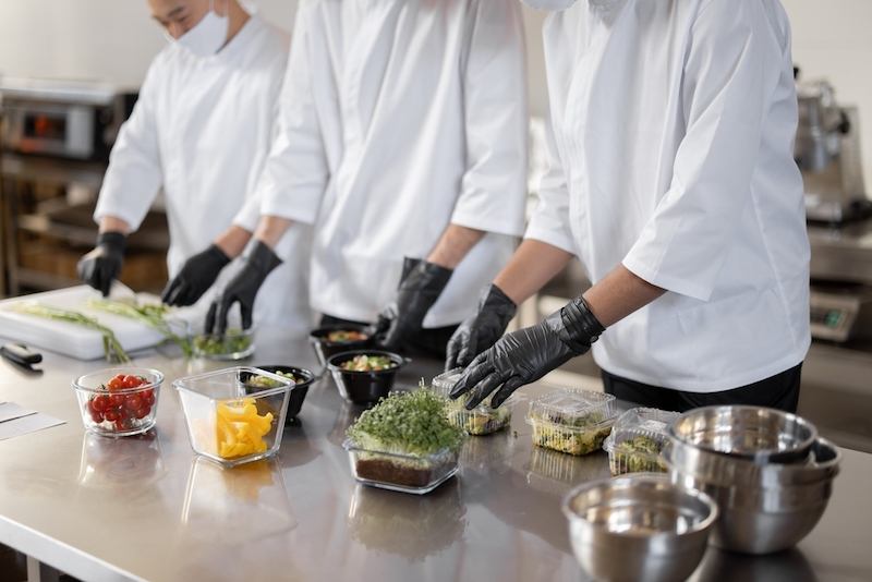 Cozinha industrial com chefs trabalhando em uma dark kitchen, otimizando processos de produção como parte de uma estratégia de marketing para delivery em João Pessoa.