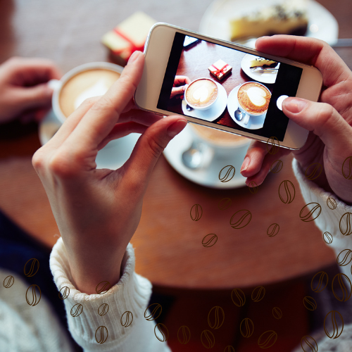 Cliente tirando foto de cafés especiais em cafeteria, representando ações de marketing digital para cafeterias nas redes sociais.