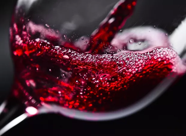 taça de vinho tinto sendo servida, close-up em movimento, ilustrando marketing para vinhos, aumentar vendas em loja de vinho e estratégias visuais atraentes para lojas de vinhos em João Pessoa.
