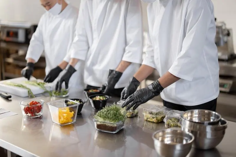 Cozinha industrial com chefs trabalhando em uma dark kitchen, otimizando processos de produção como parte de uma estratégia de marketing para delivery em João Pessoa.
